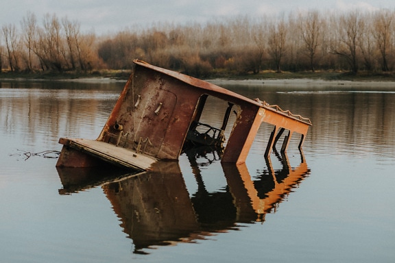 Old boat shipwreck in flood water pollution