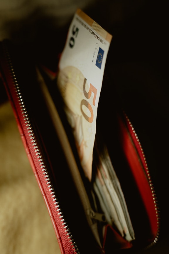 50 euro banknote in dark red wallet full of money