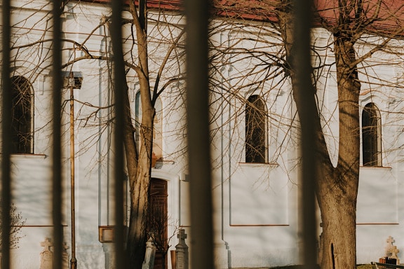 Facade of orthodox church with gravestones in backyard