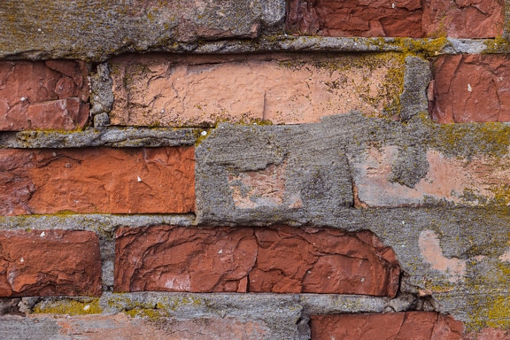 Old dark red bricks wall with mortar decomposition texture