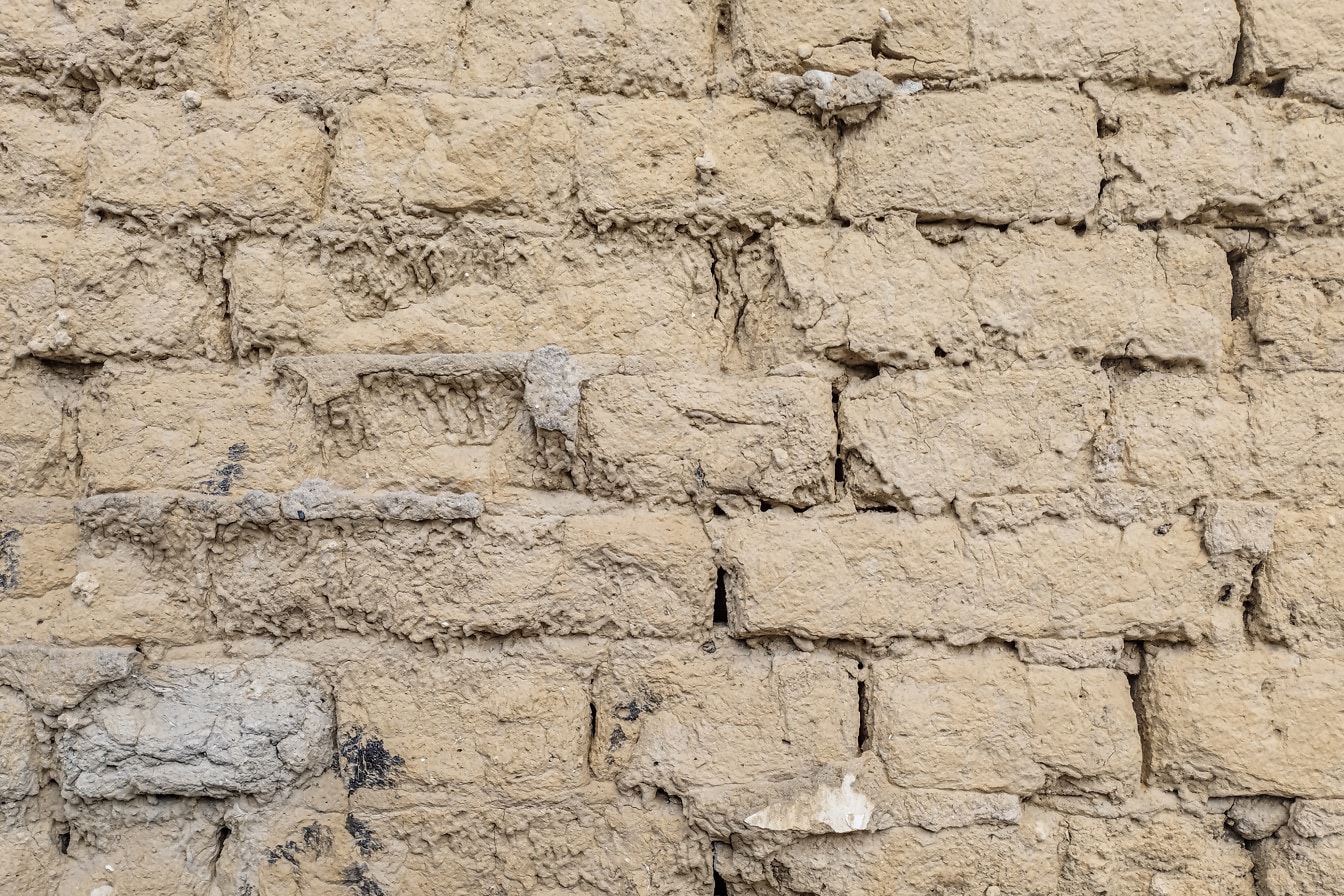 Primer plano de la textura de la pared de ladrillo de adobe de la tierra seca