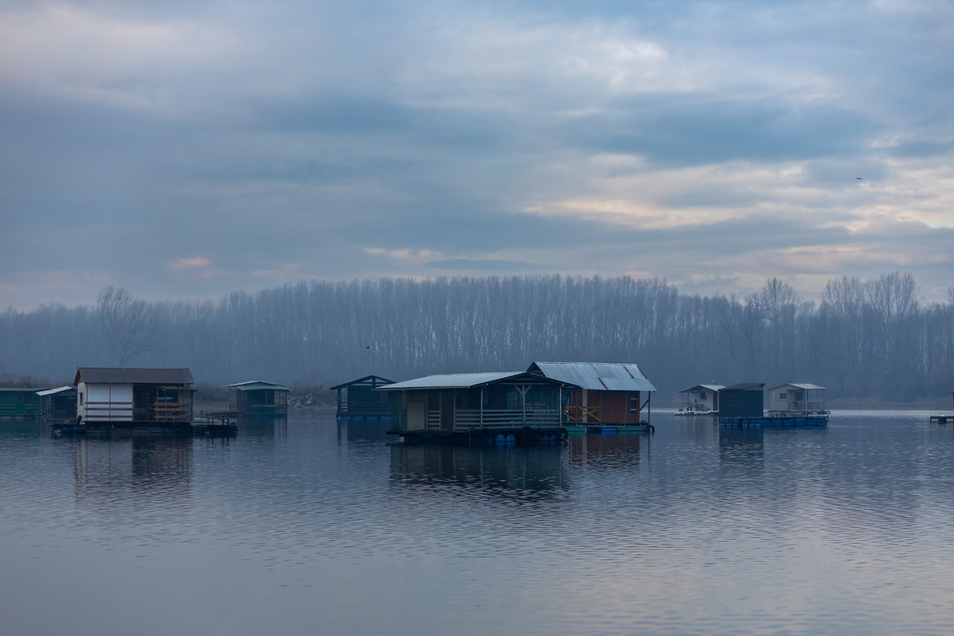 Alacakaranlıkta göl kenarındaki tatil beldesinde birçok tekne evi