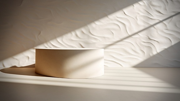 Minimalismus Perfektion: runder beigefarbener Marmor auf weißem Boden im Schatten
