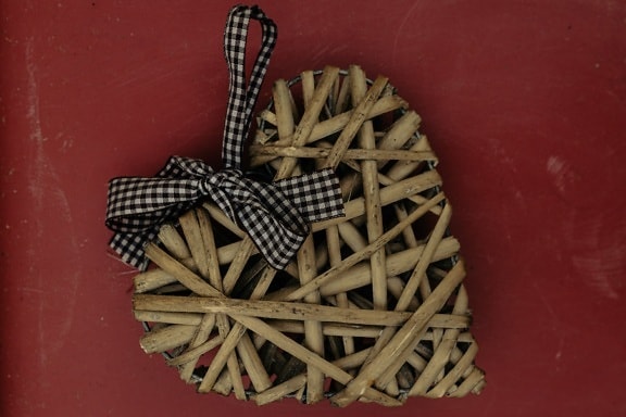Handmade wicker heart with ribbon Valentine’s day gift close-up