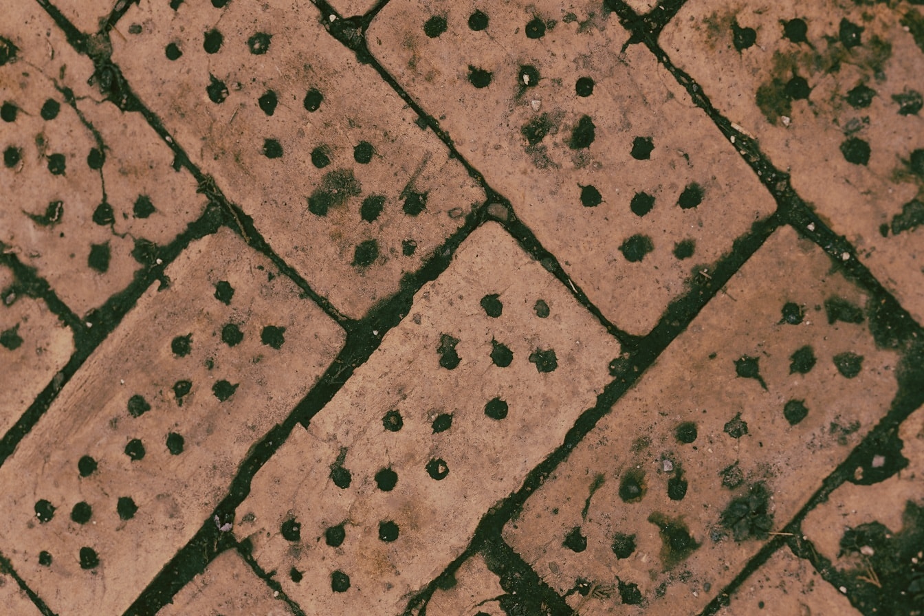 Ladrillos antiguos geométricos diagonales con textura de agujeros