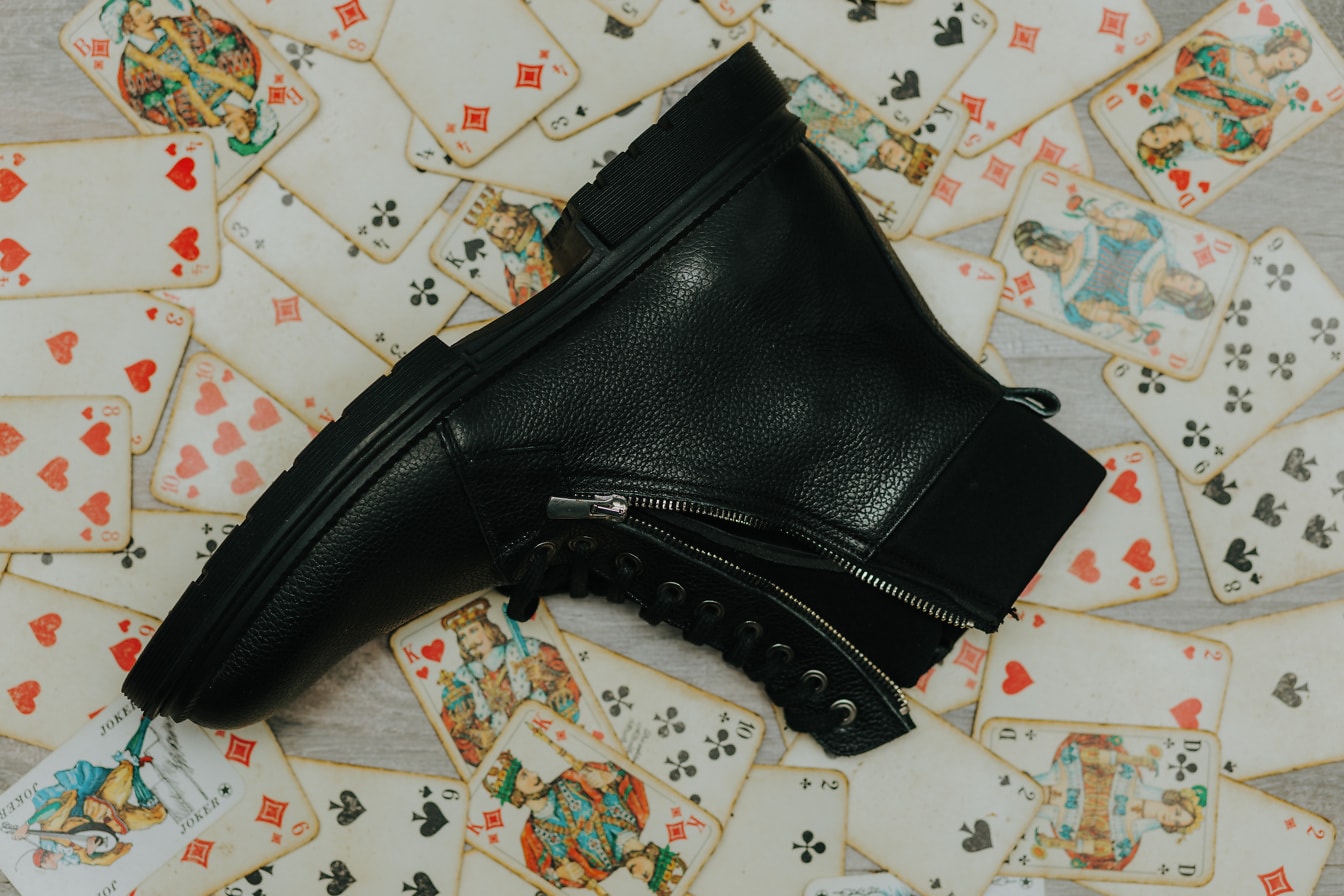 Black leather boot on old-style playing card