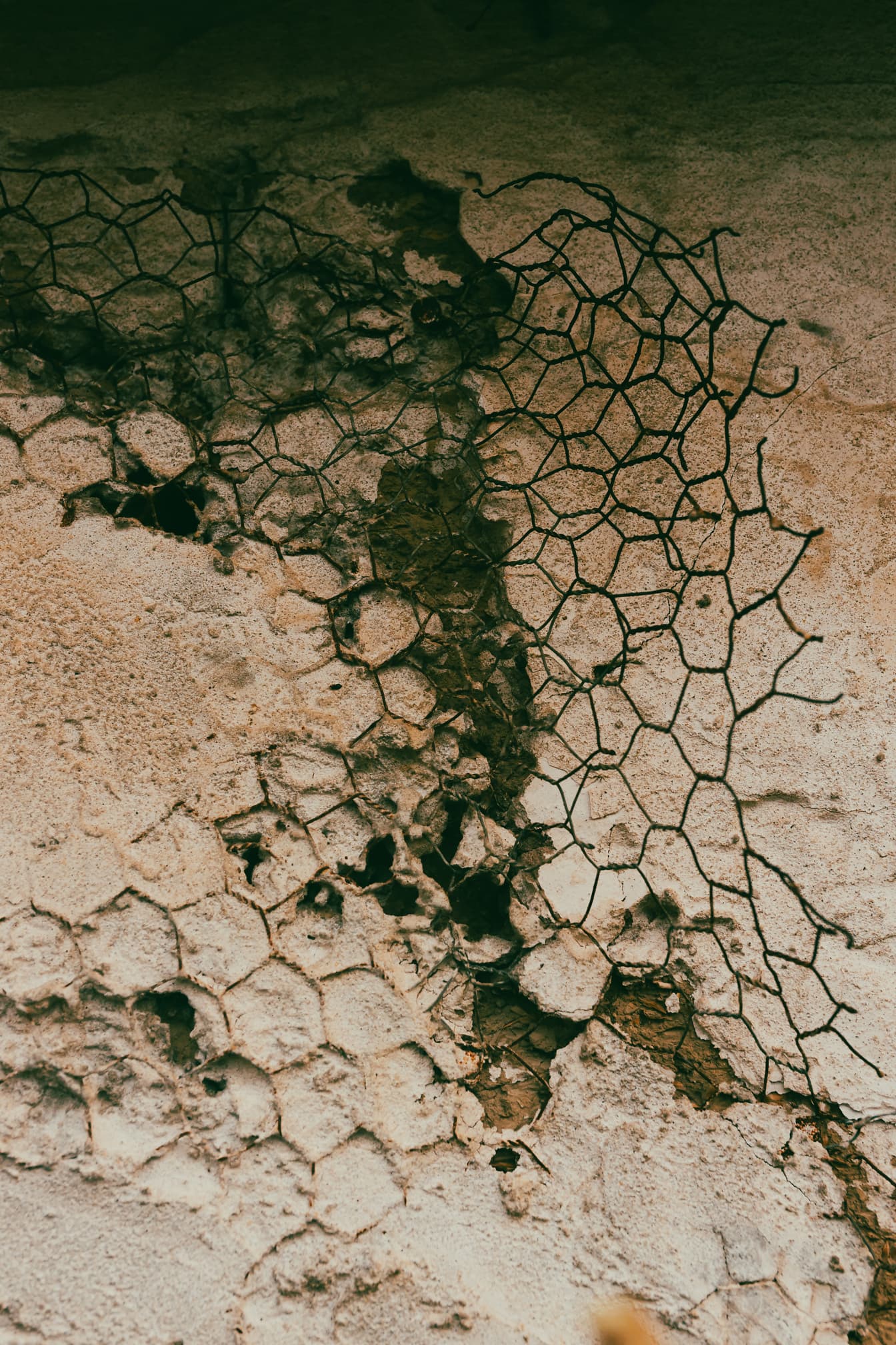 Vanhat ruosteiset rautalangat adobe-tiiliseinällä sementissä