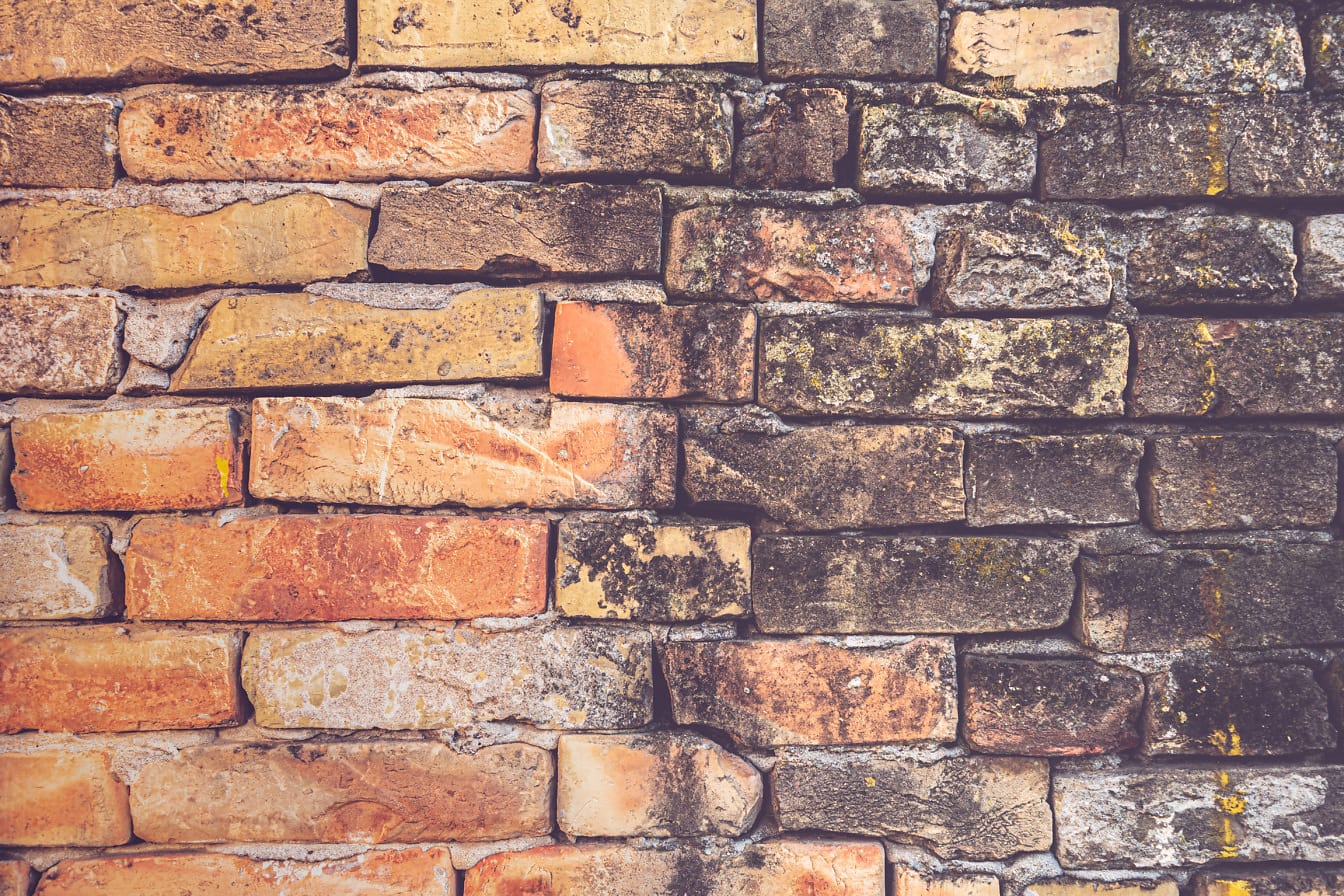 Orange yellow brick wall texture with dark dirty bricks