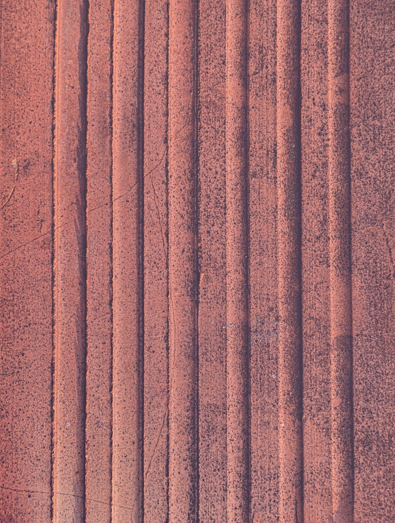 Close-up of rough terracotta texture with vertical lines