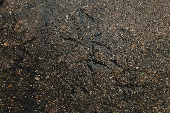 Surface of wet dark rough concrete