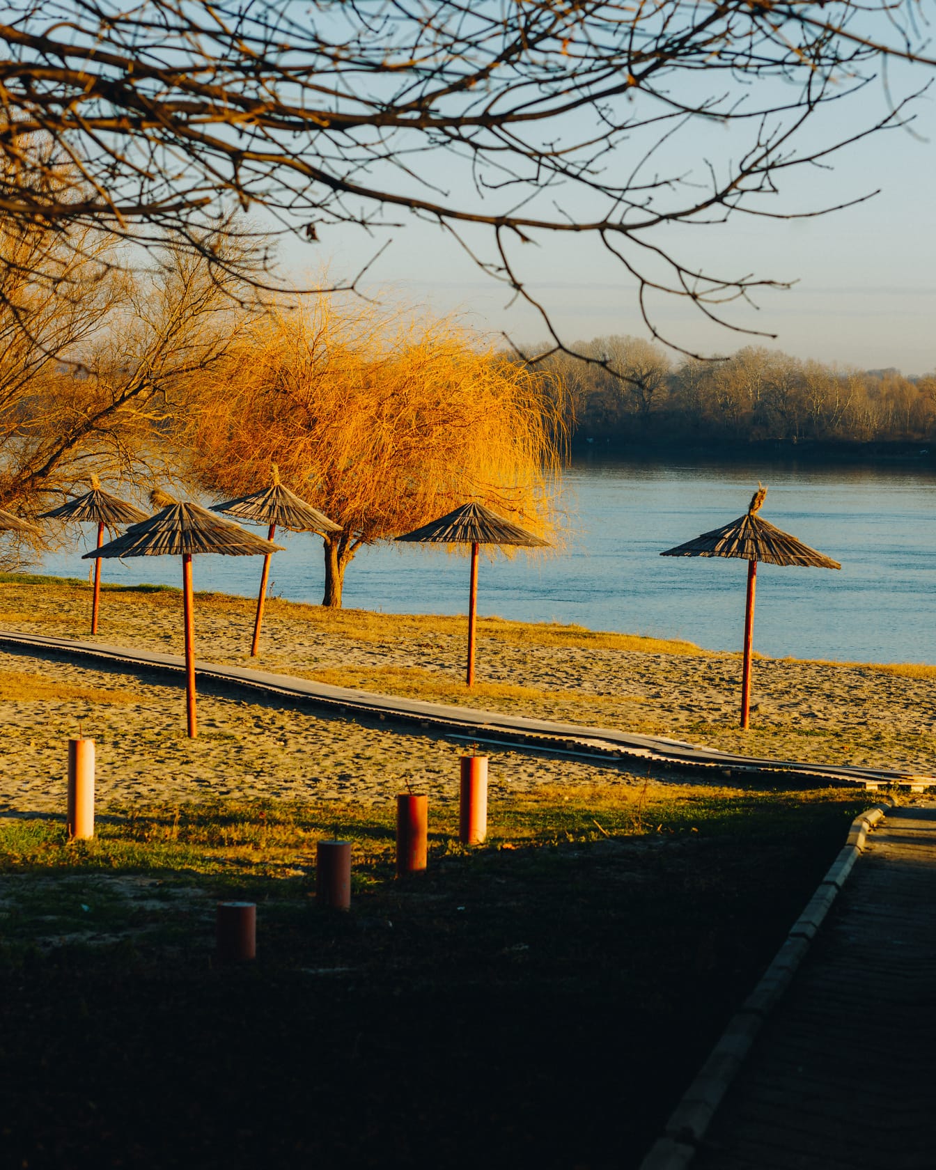 După-amiază însorită cu umbrele de soare pe plaja Dunării