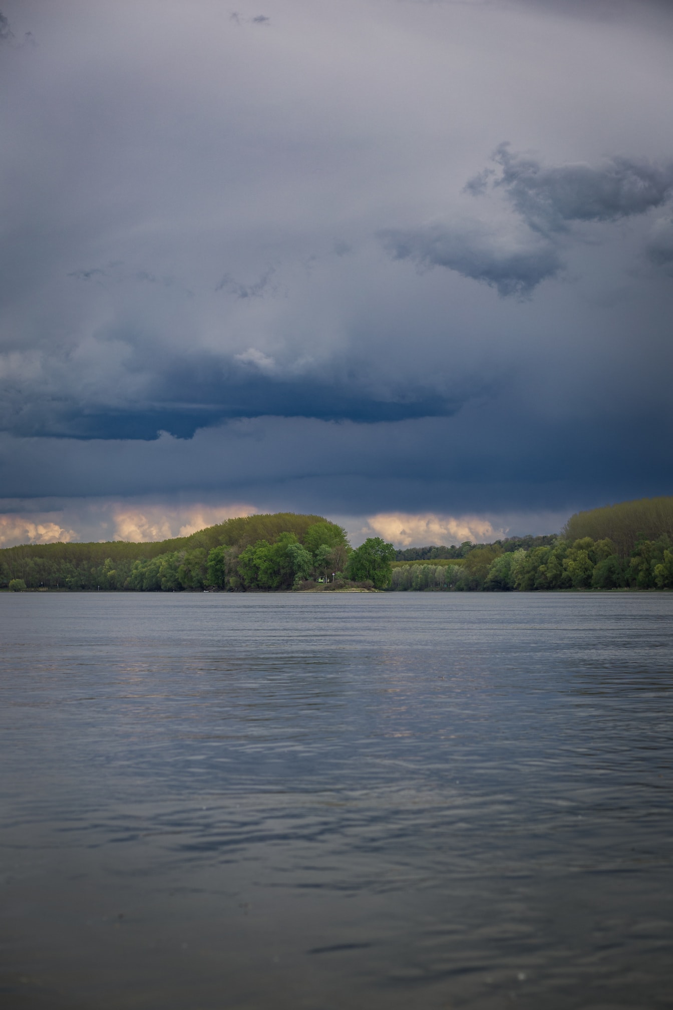Donkerblauwe onweerswolken boven de rivier van Donau