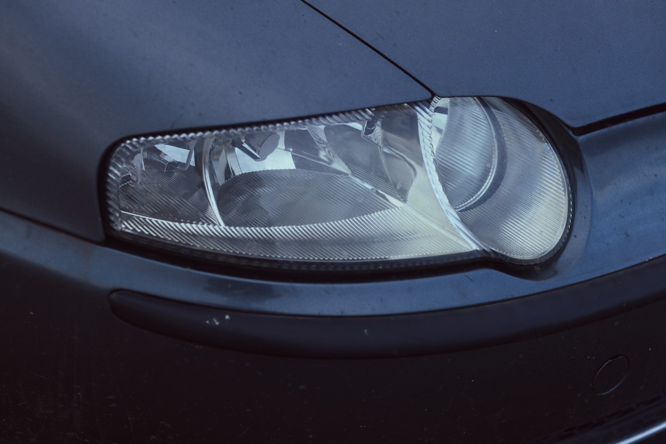 Zbliżenie reflektora na metalicznym ciemnoniebieskim samochodzie