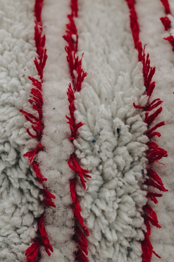 Dark red fiber vertical lines in white wool texture