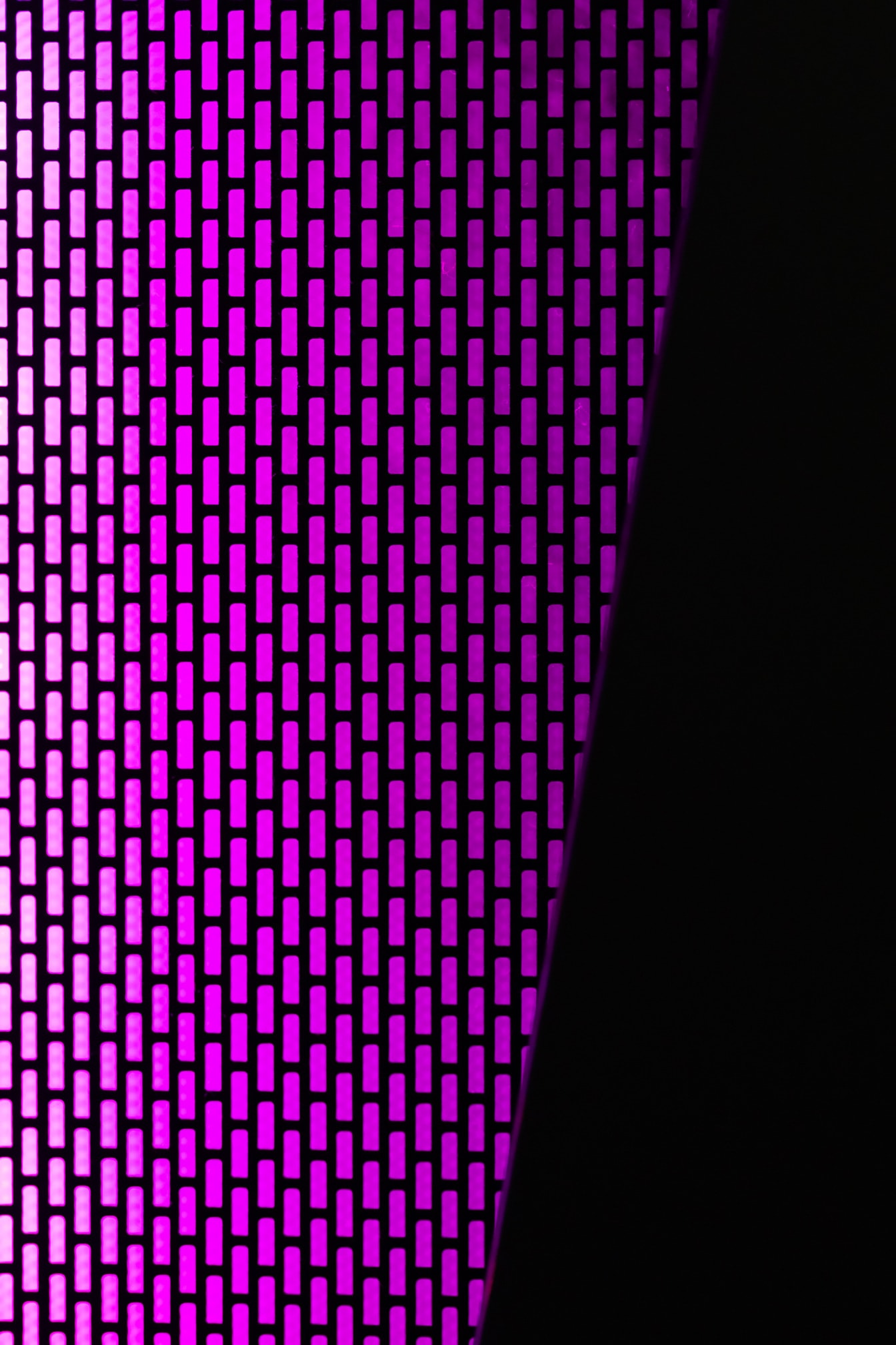 Zářivá jasně fialová geometrická textura ve tmě