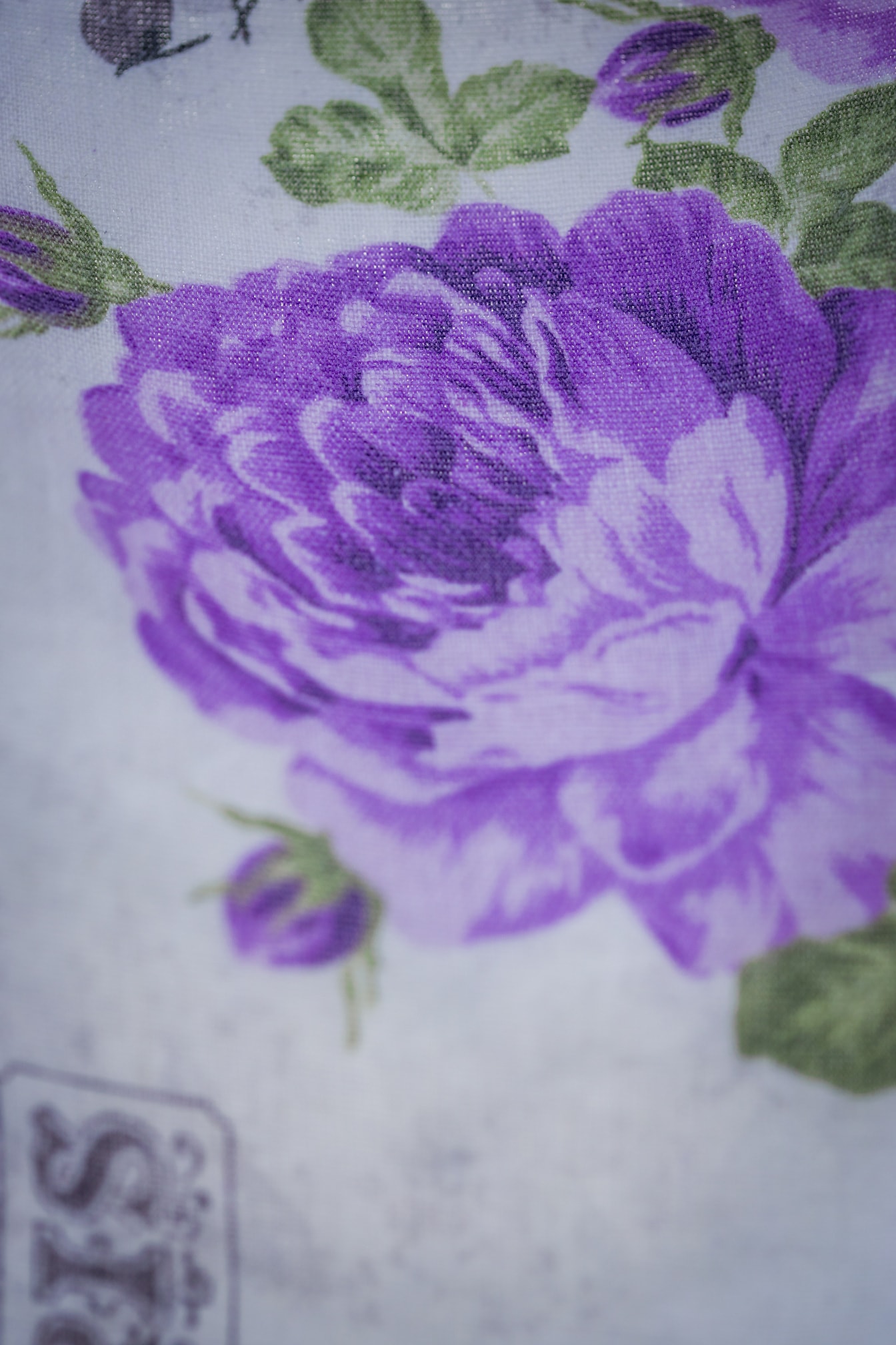 Textura close-up da tela de algodão com ilustração de flores arroxeadas