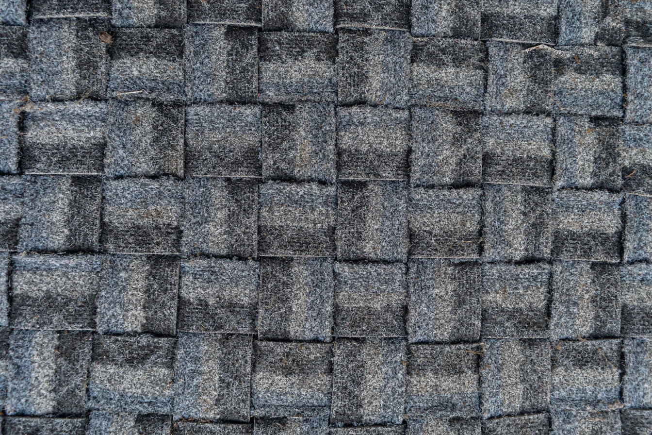 Nahaufnahme der Textur aus dunkelblauem und schwarzem Kunststoff Fußmatte