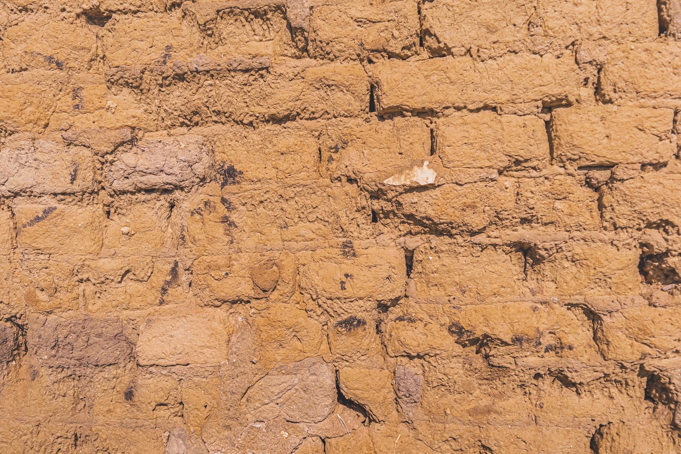 Textura rugosa de pared de ladrillos de adobe de color marrón amarillento