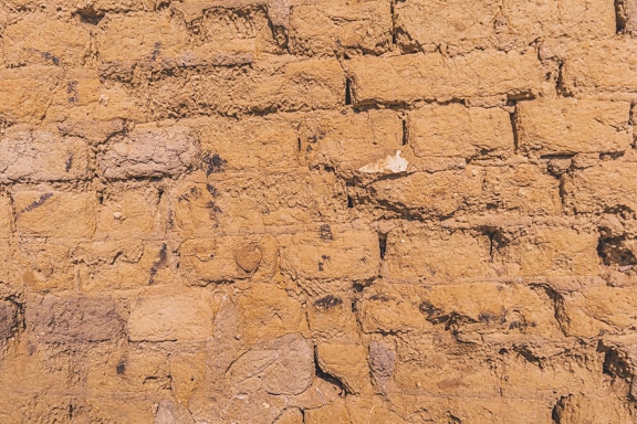 Rough yellowish brown adobe bricks wall texture
