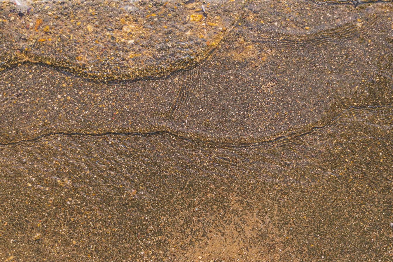 Брызги воды на мокром желтовато-коричневом бетоне