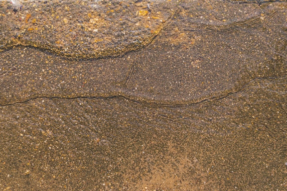 Víz fröccsen nedves sárgásbarna betonon