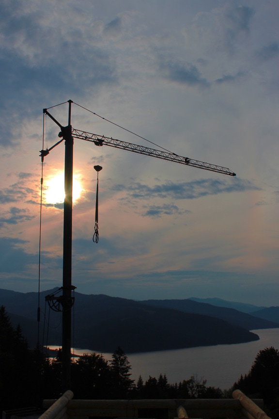 Silhouette of industrial crane in mountainside construction site