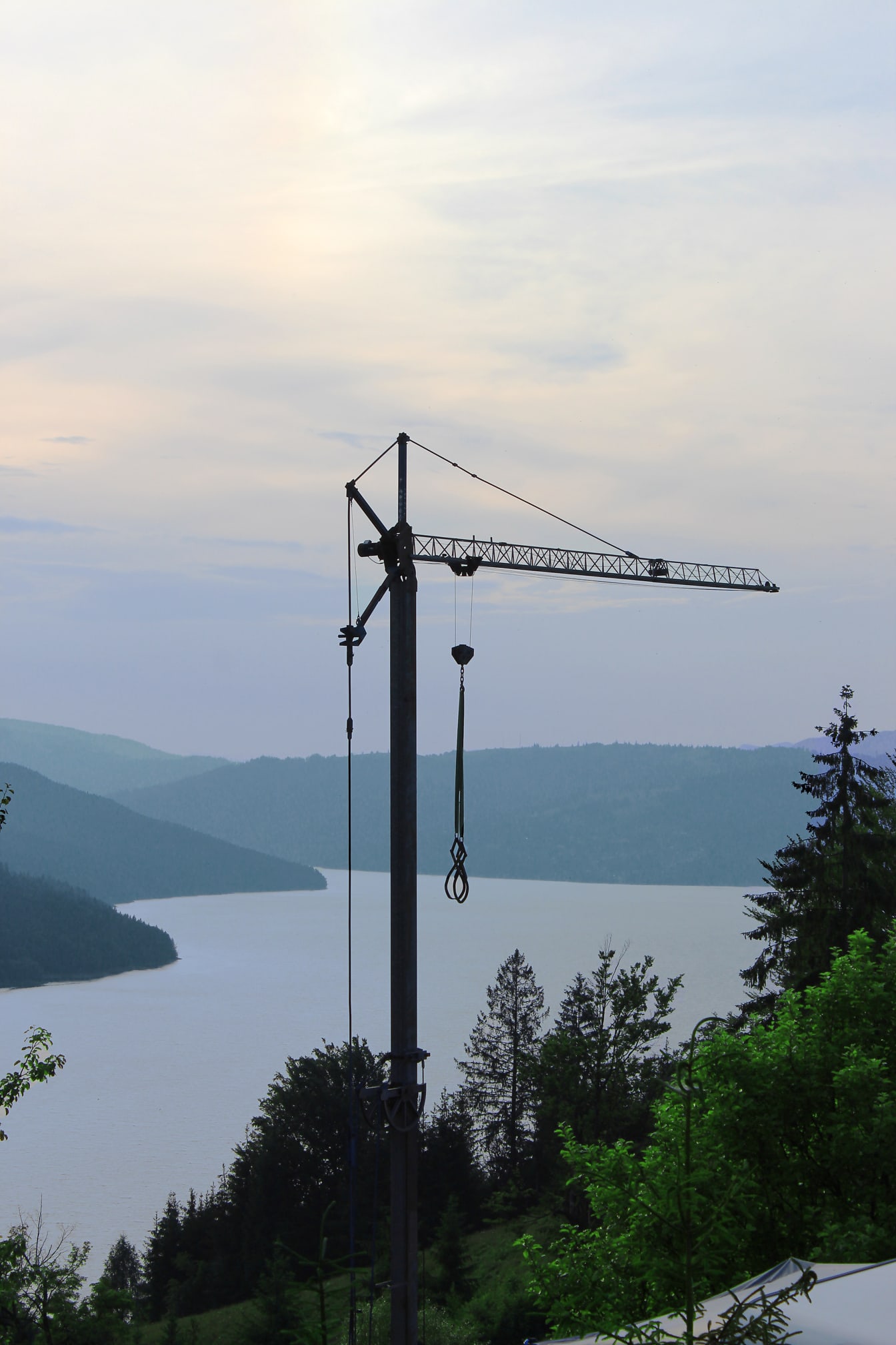 Wysoki żuraw przemysłowy w górach nad jeziorem