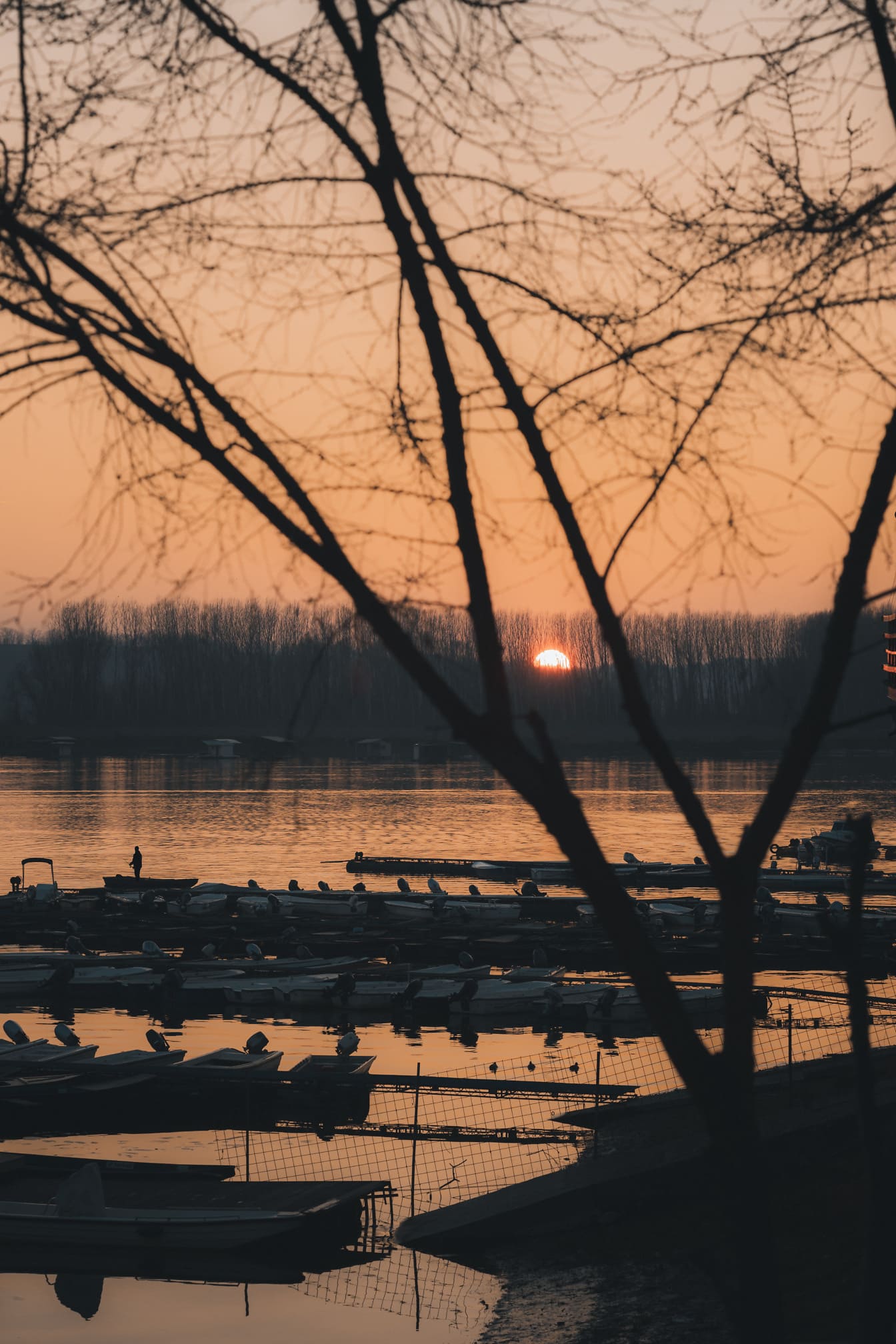 Východ slunce v přístavu na břehu jezera, klidná atmosféra