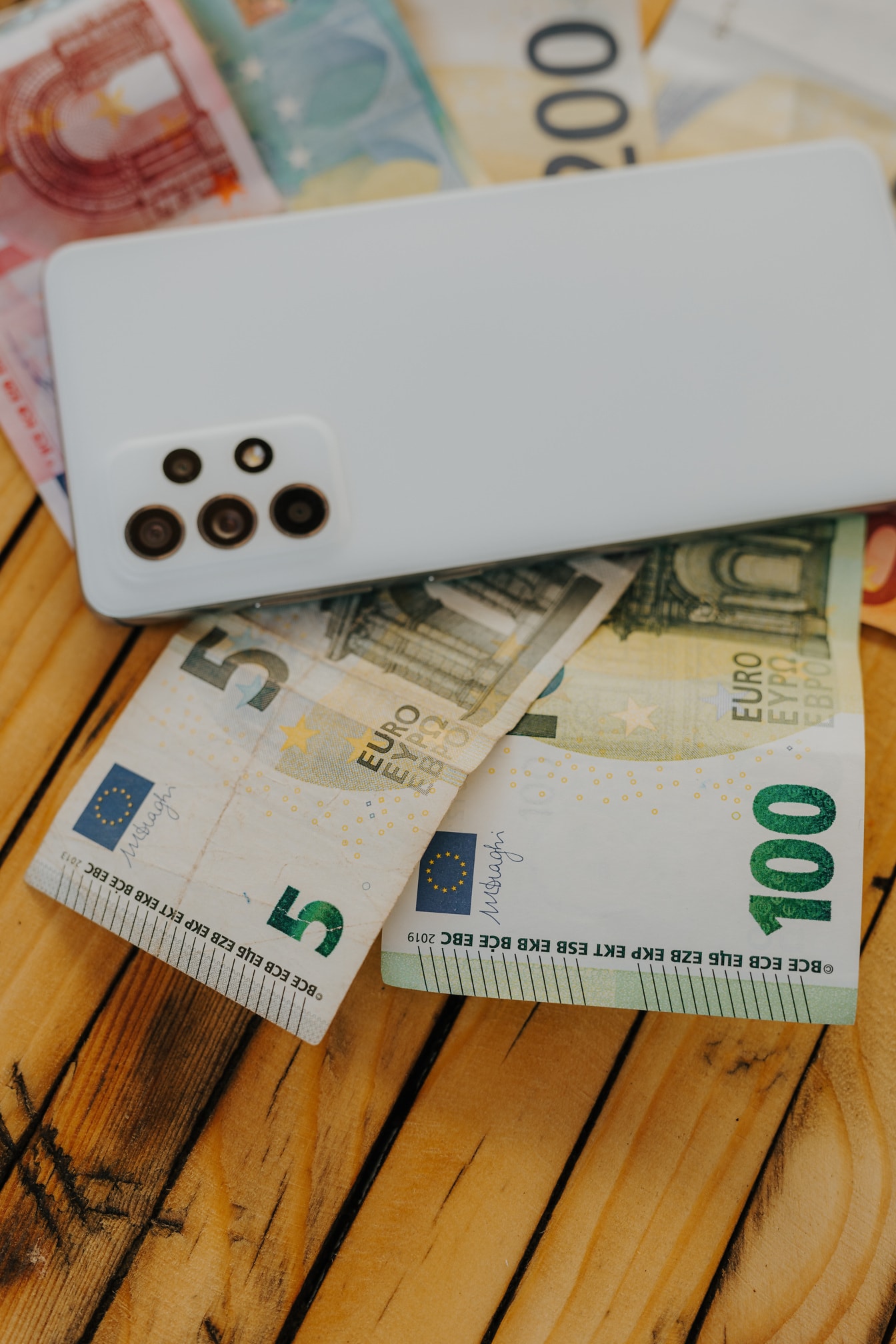 Eurové bankovky s bielym mobilným telefónom