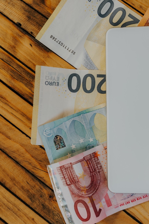 Close-up of Euro banknotes on rustic wooden table planks