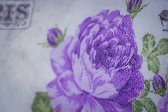 Nahaufnahme Leinwandtextur violette Blume auf Baumwolltextil
