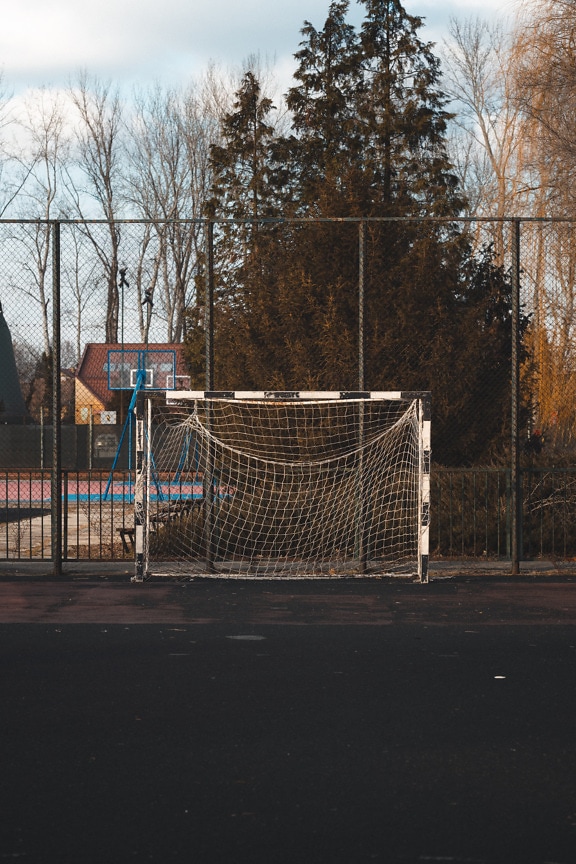 Empty football goal with basketball court in background
