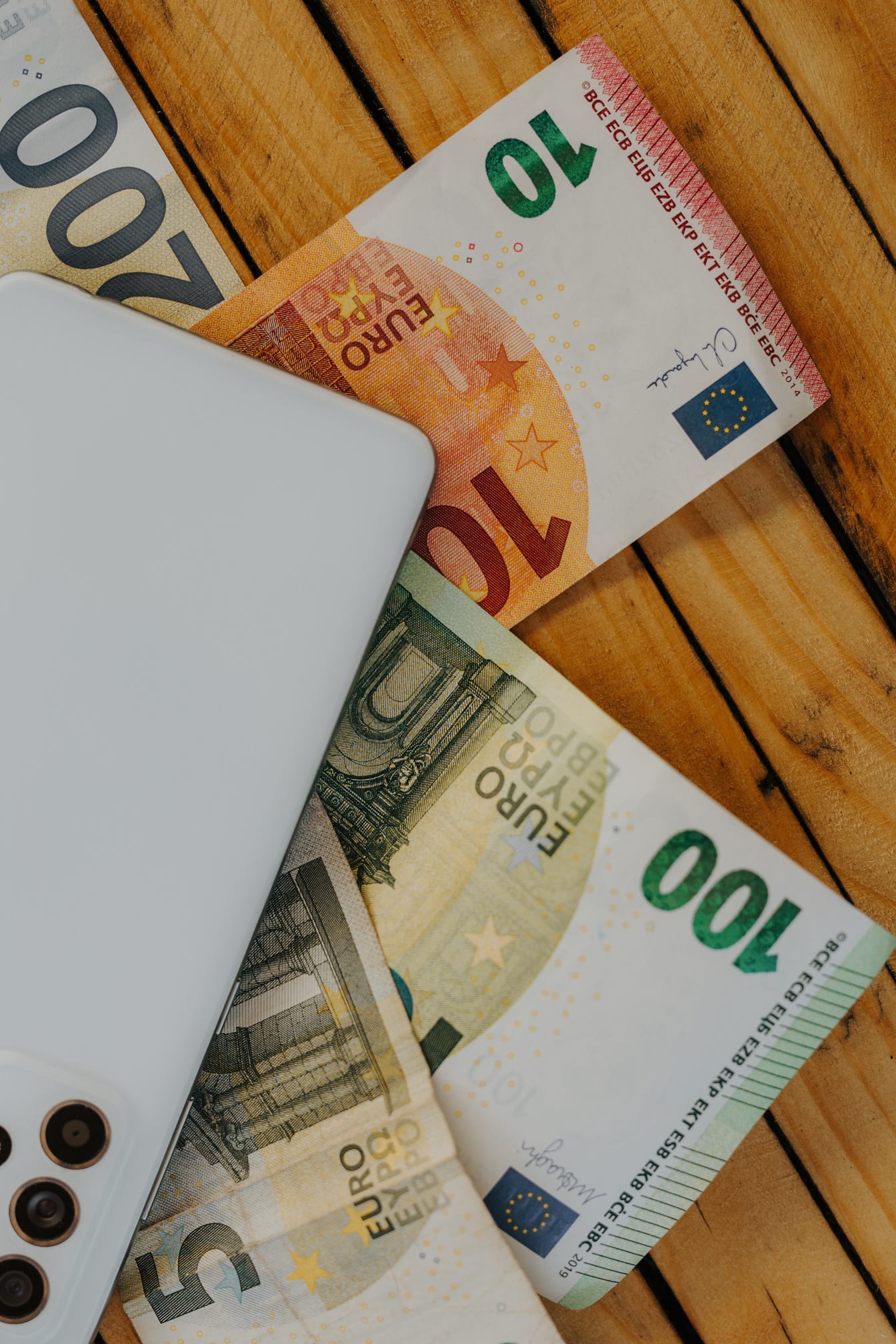 ユーロ紙幣、紙幣、木の板に白い携帯電話