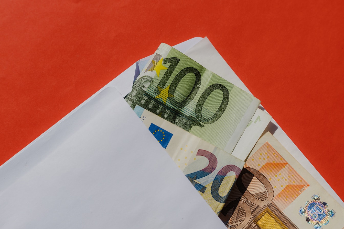 Euro banknotes paper money in white envelope with red background