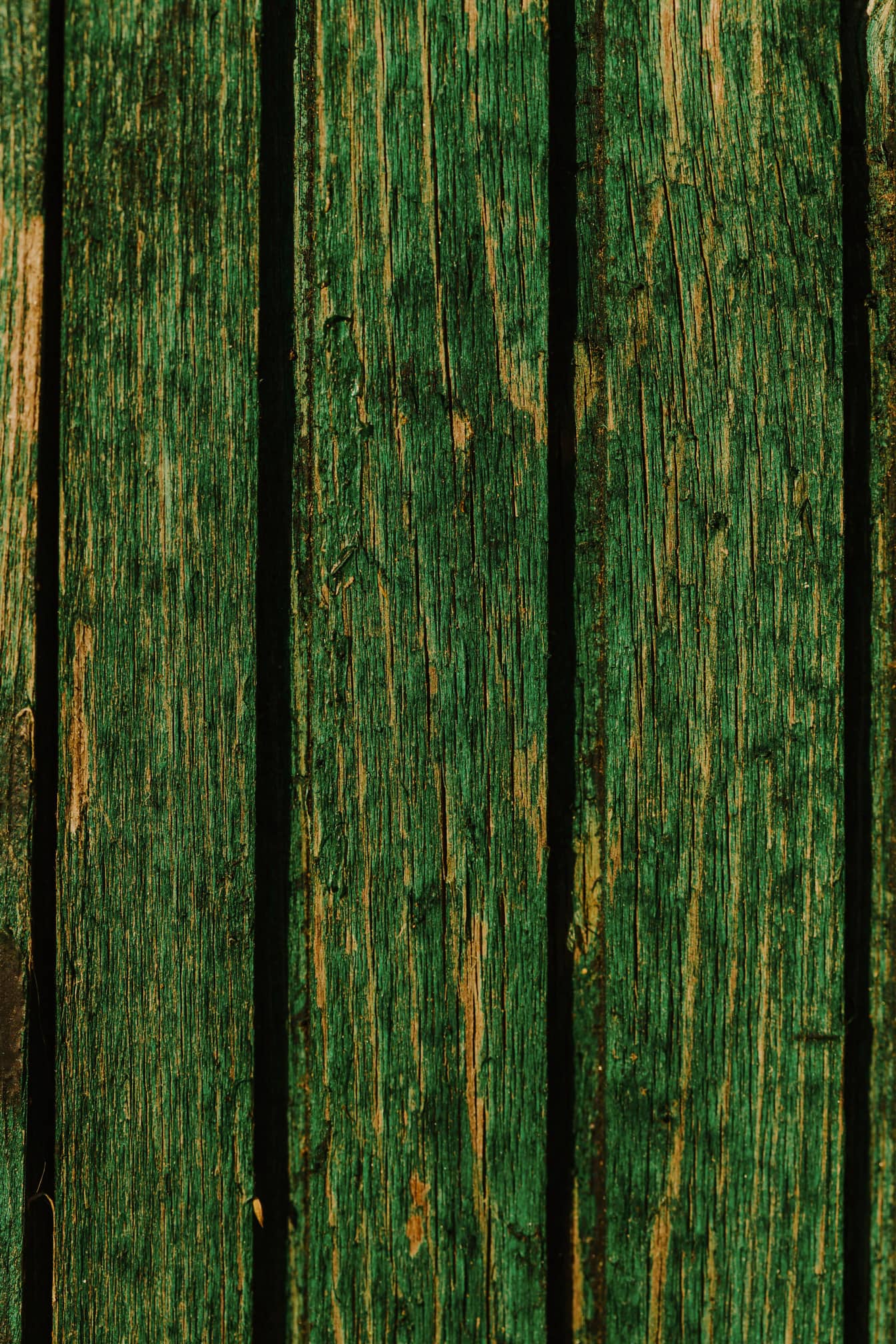 Dunkelgrüne Farbe auf alten vertikalen Holzbohlen