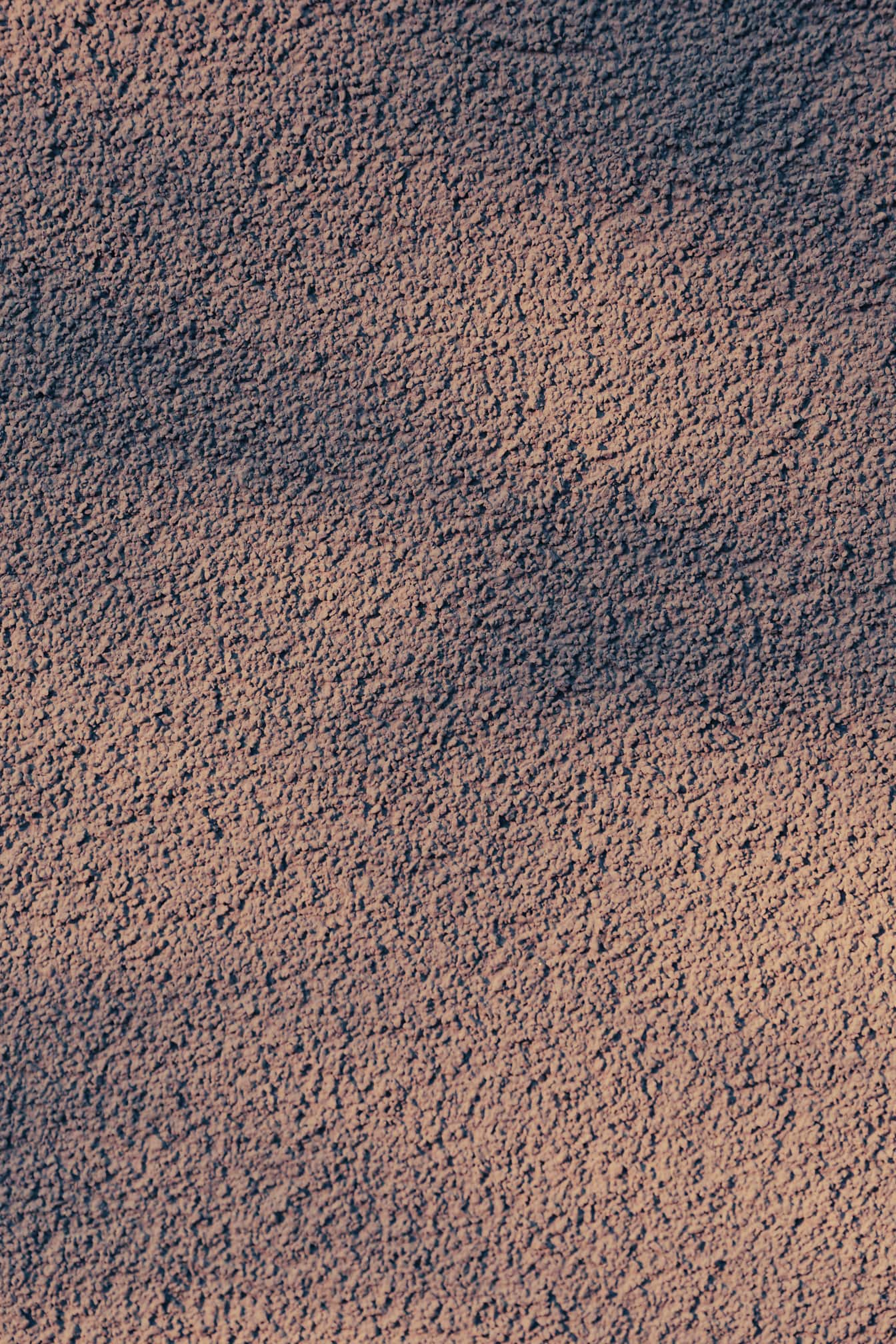 Яркая пурпурная текстура шероховатой цементной стены с тенью