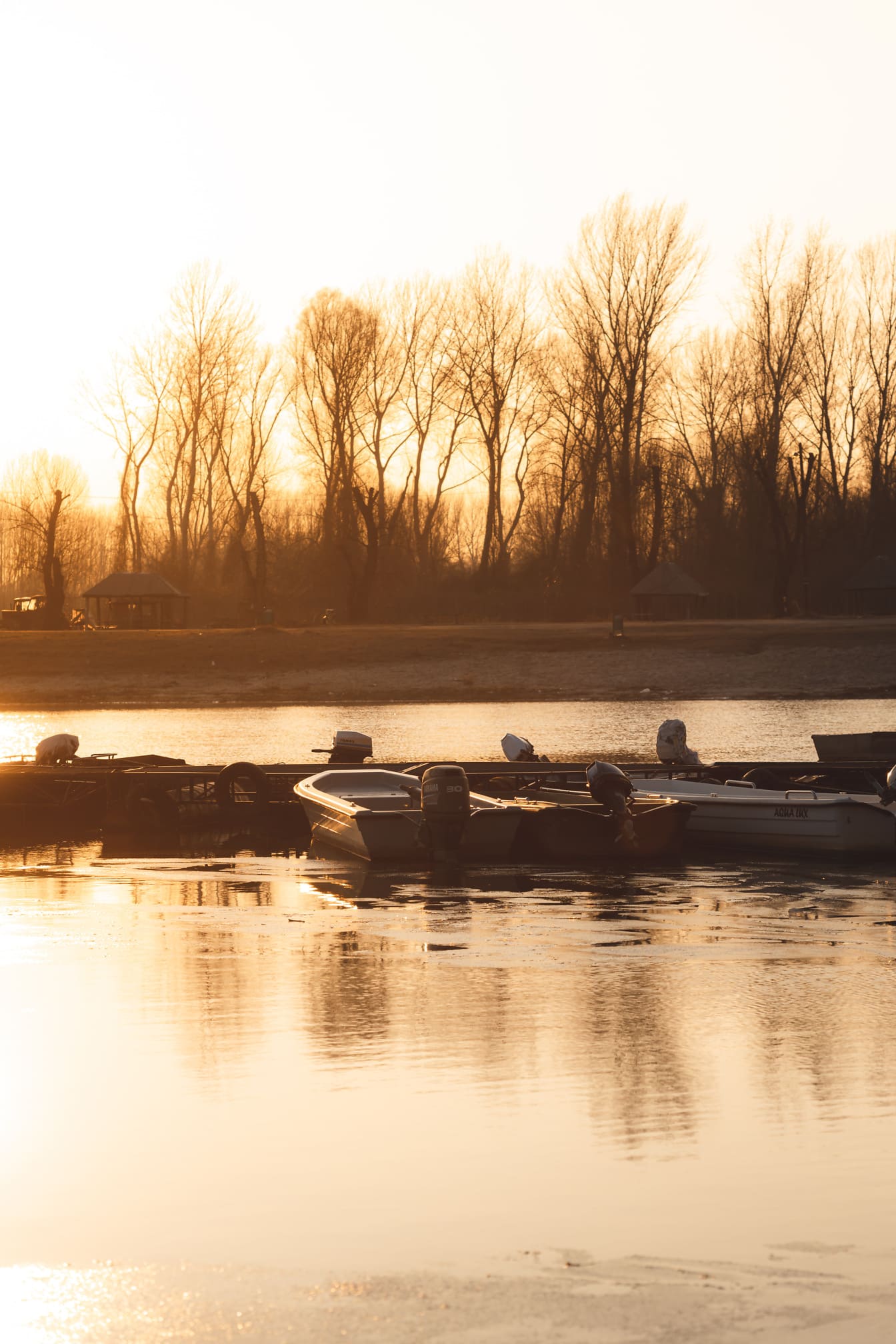 Słońce w porcie na jeziorze z łodziami rybackimi w sezonie letnim