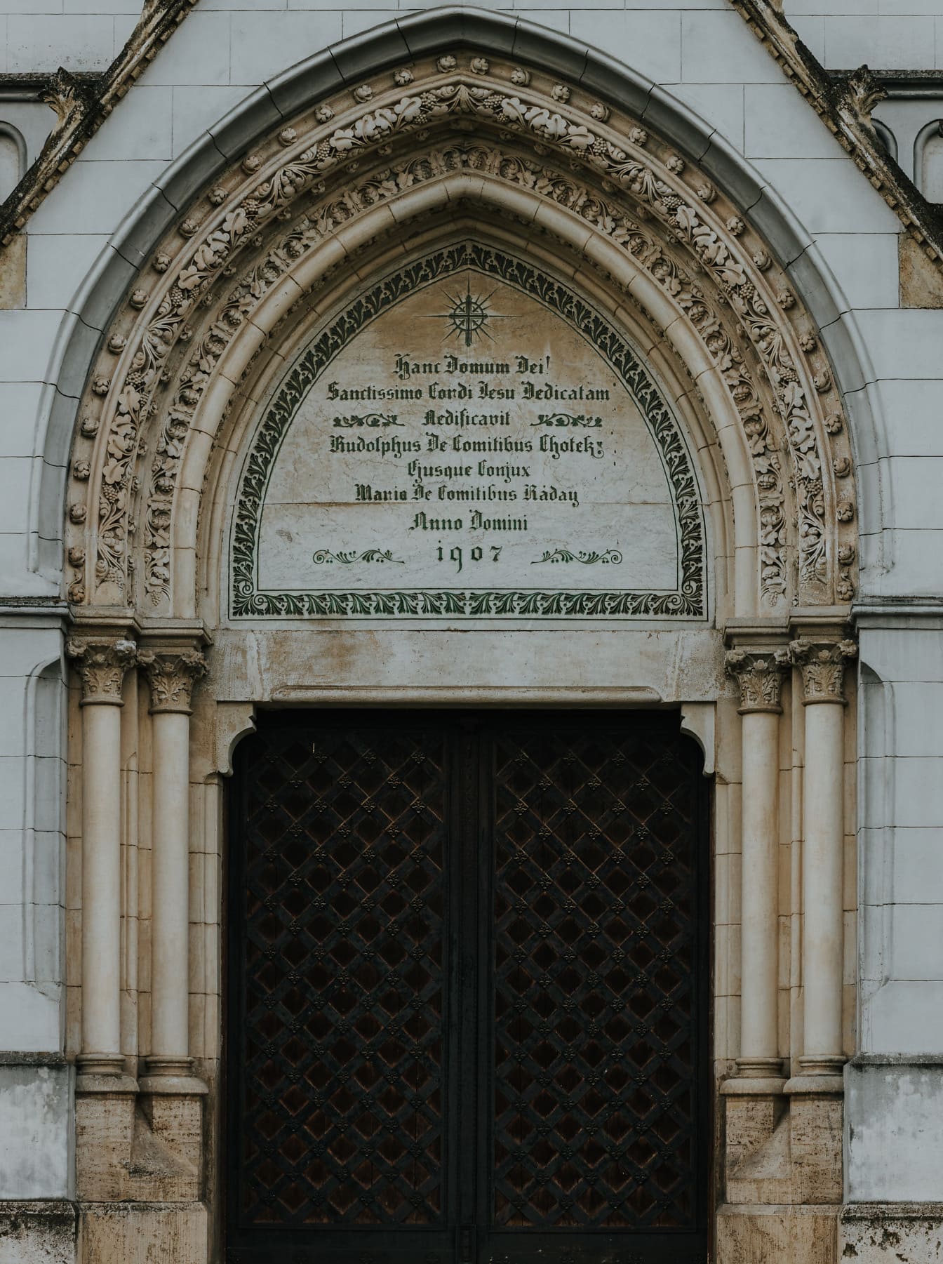 Gusseiserne Haustür mit Steinbogen im gotischen Stil