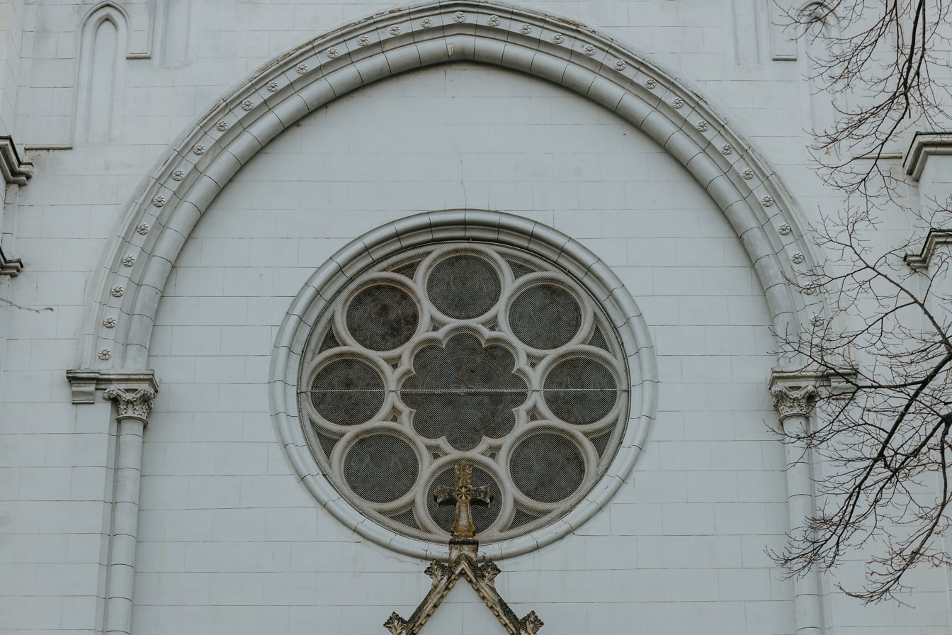 Stenkors med cirkelfönster i gotisk stil i bakgrunden