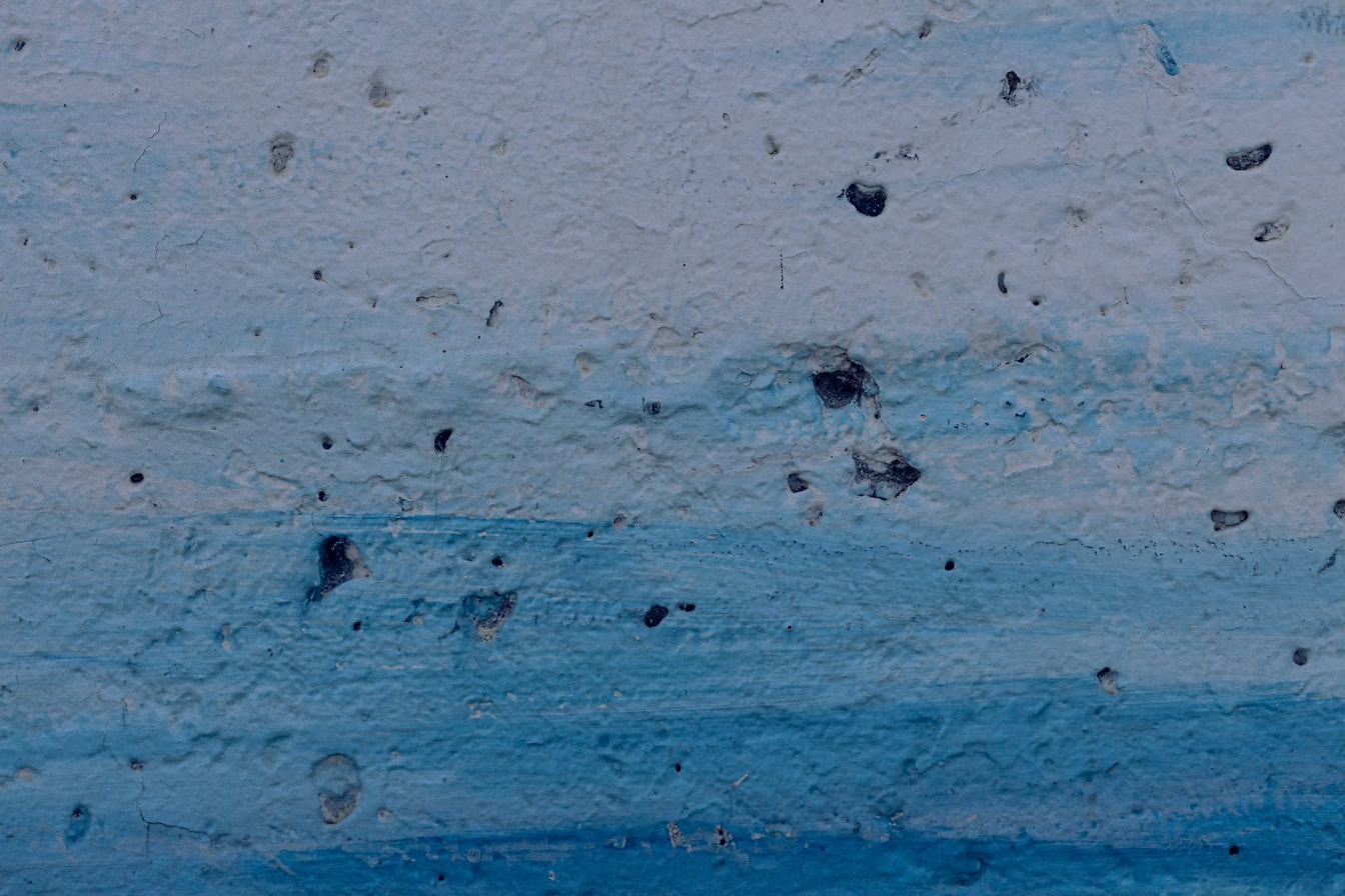 Blauwe verf op ruwe betonnen muur close-up textuurverf