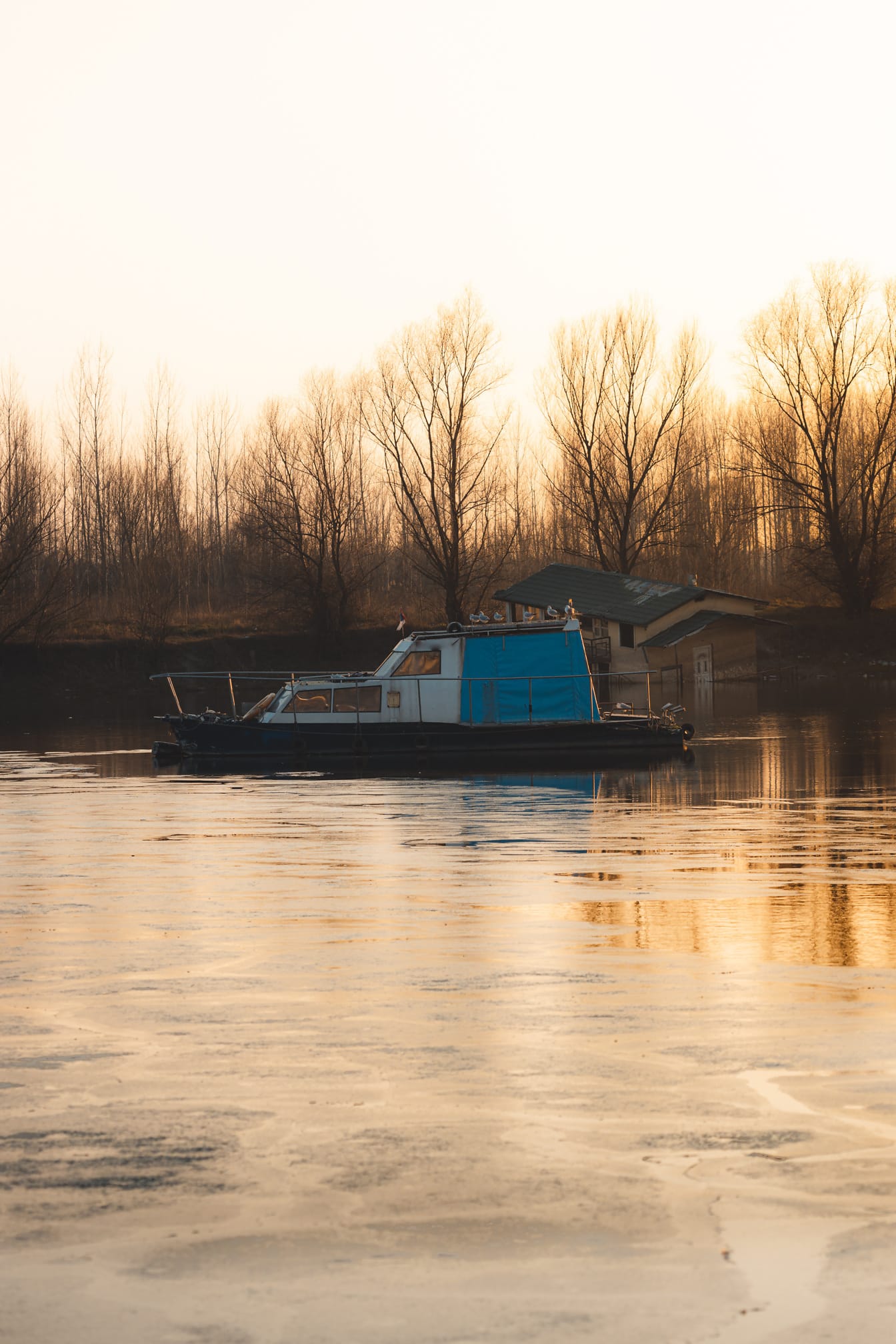Вид сбоку на маленькую рыбацкую лодку на спокойном озере в осенний сезон