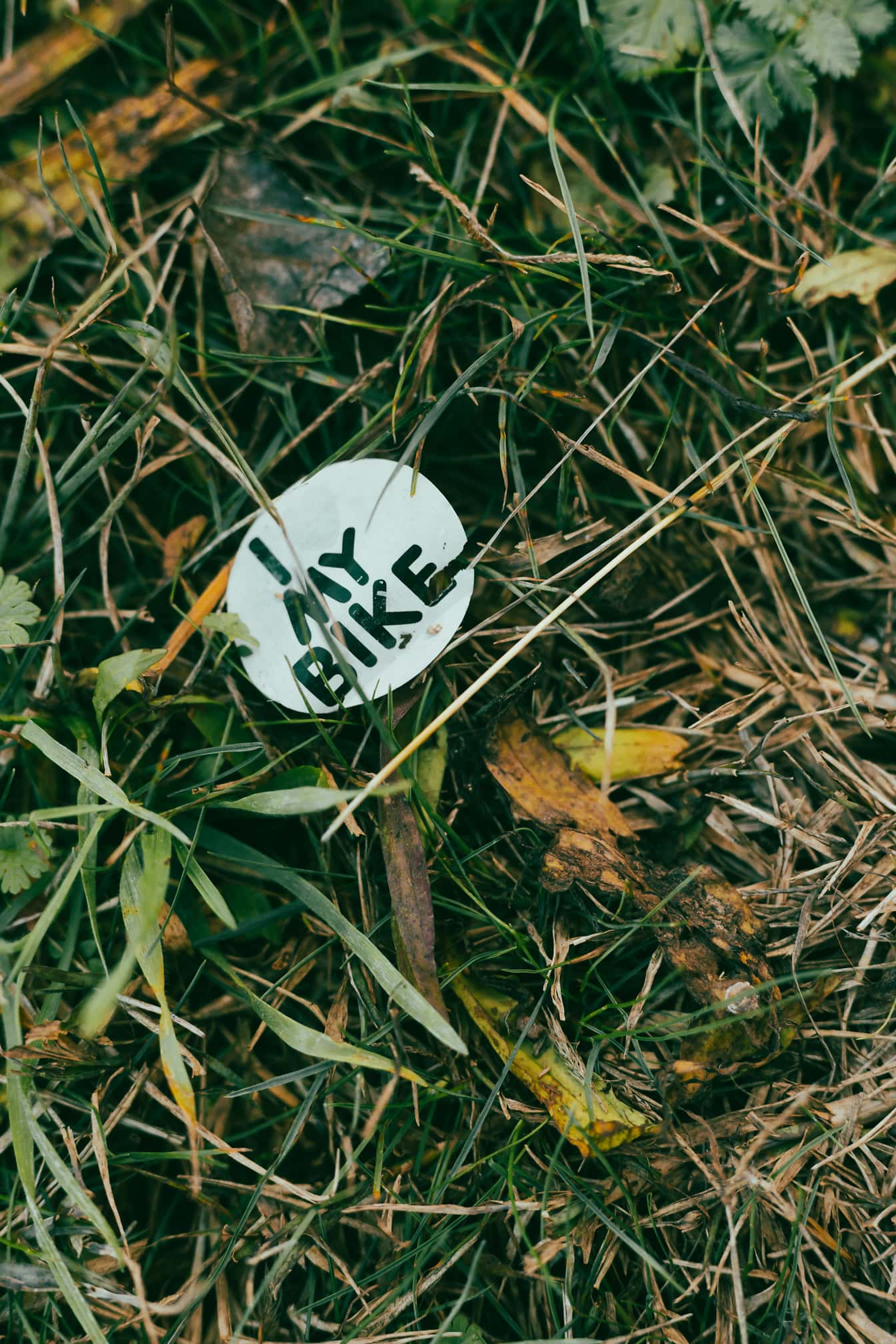 Svartvitt pappersklistermärke för skräp med text i gräs