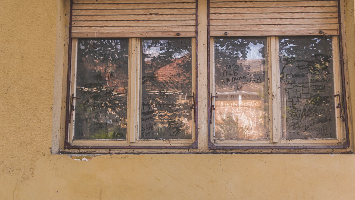 Cửa sổ mục nát kiểu cũ trên ngôi nhà bỏ hoang