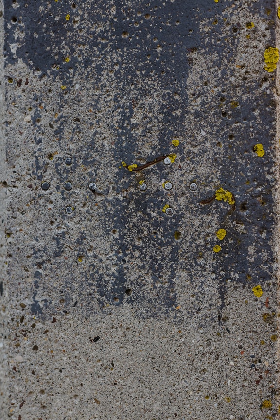 Närbild av förfallen betongyta med metalltrådar