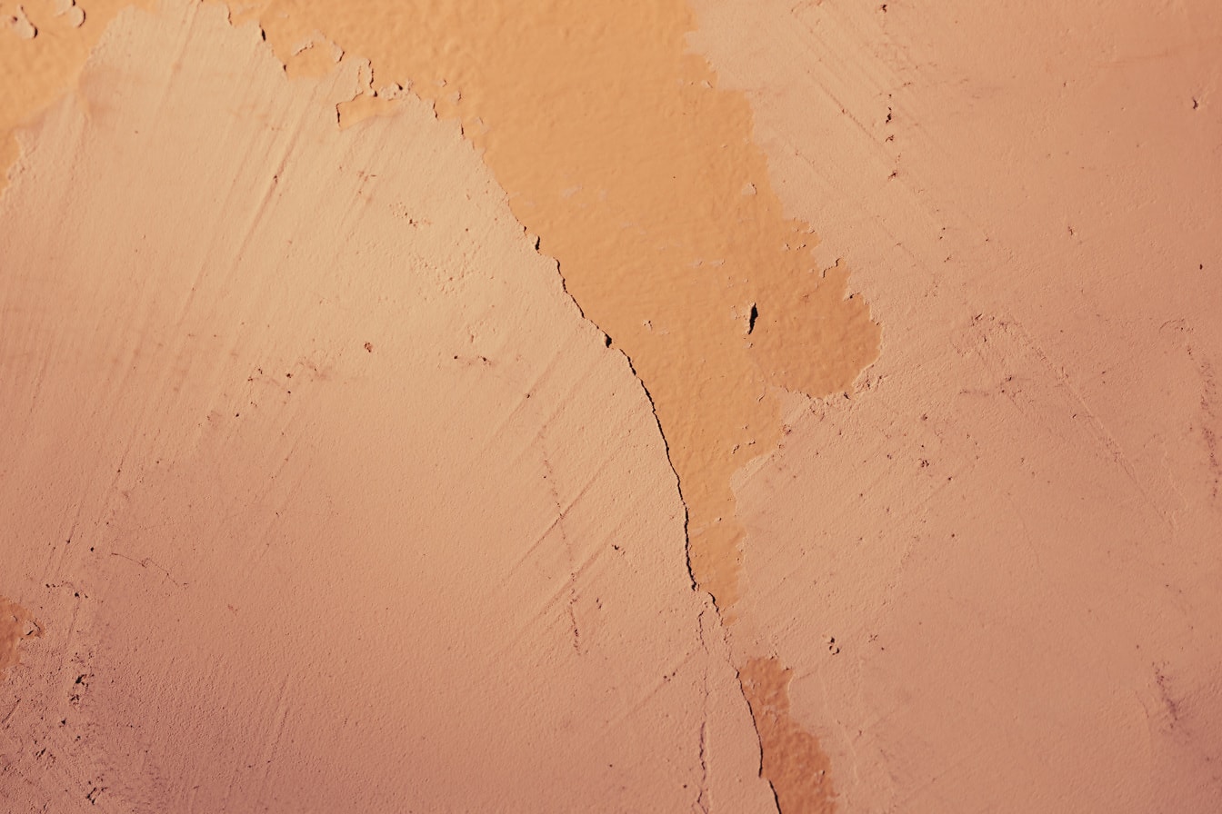 Bright orange yellow rough paint on wall texture