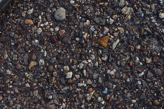 Wet rough concrete surface with pebbles texture