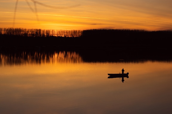 Majestic orange-yellow sunset reflection on calm lake water level
