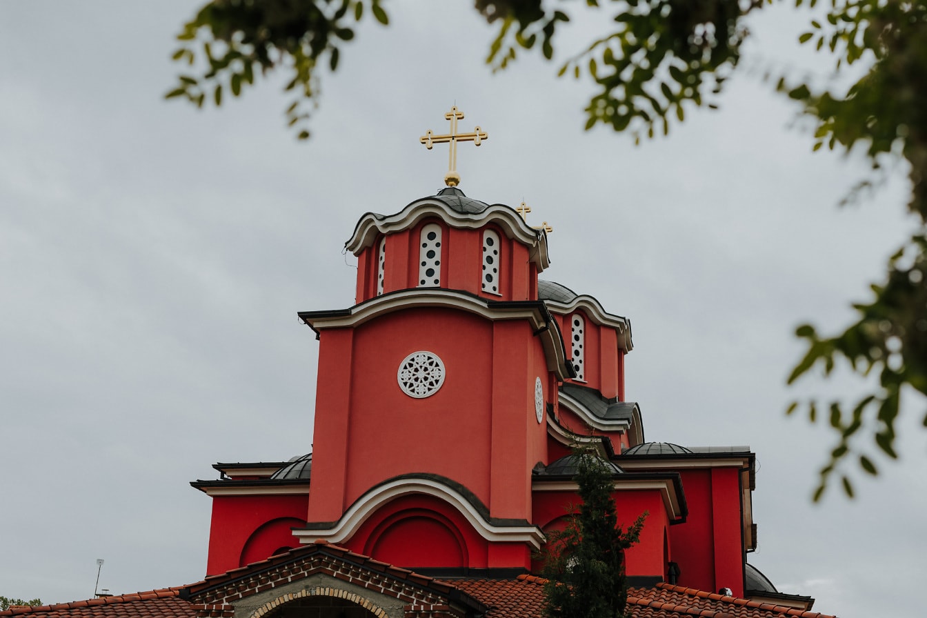 Σκούρο κόκκινο καμπαναριό ορθόδοξης εκκλησίας σε βυζαντινό αρχιτεκτονικό ρυθμό