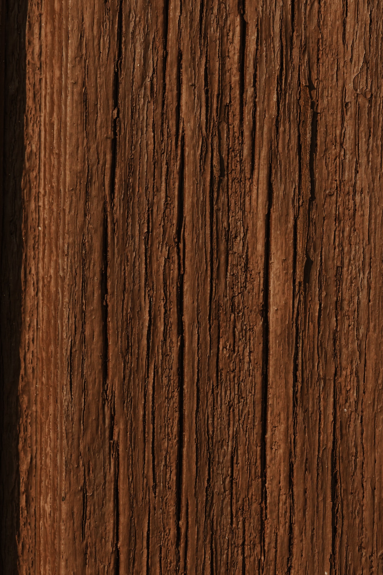 Close-up of brown rough paint on wooden plank