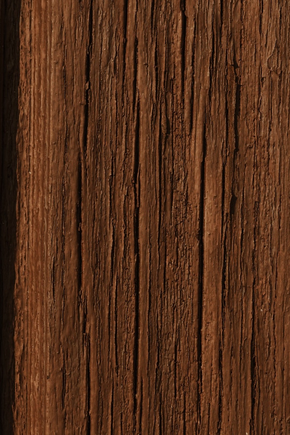 Gros plan de peinture brune rugueuse sur une planche de bois